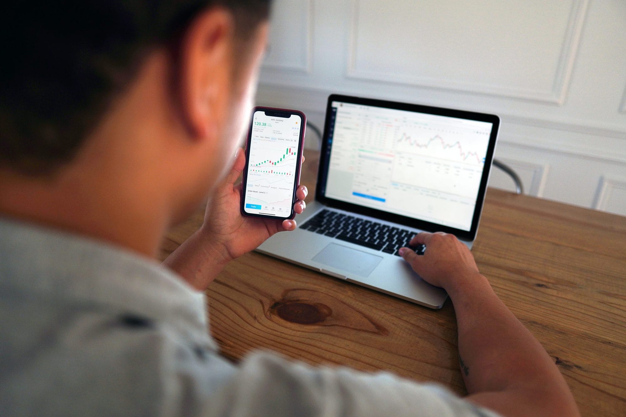 man in front of computer looking at stocks